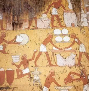 Bakers mixing and kneading dough and filling bread molds, from a painting in an ancient Egyptian tomb.